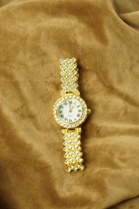 Zegarek w złotym kolorze z ozdobnymi kamieniami